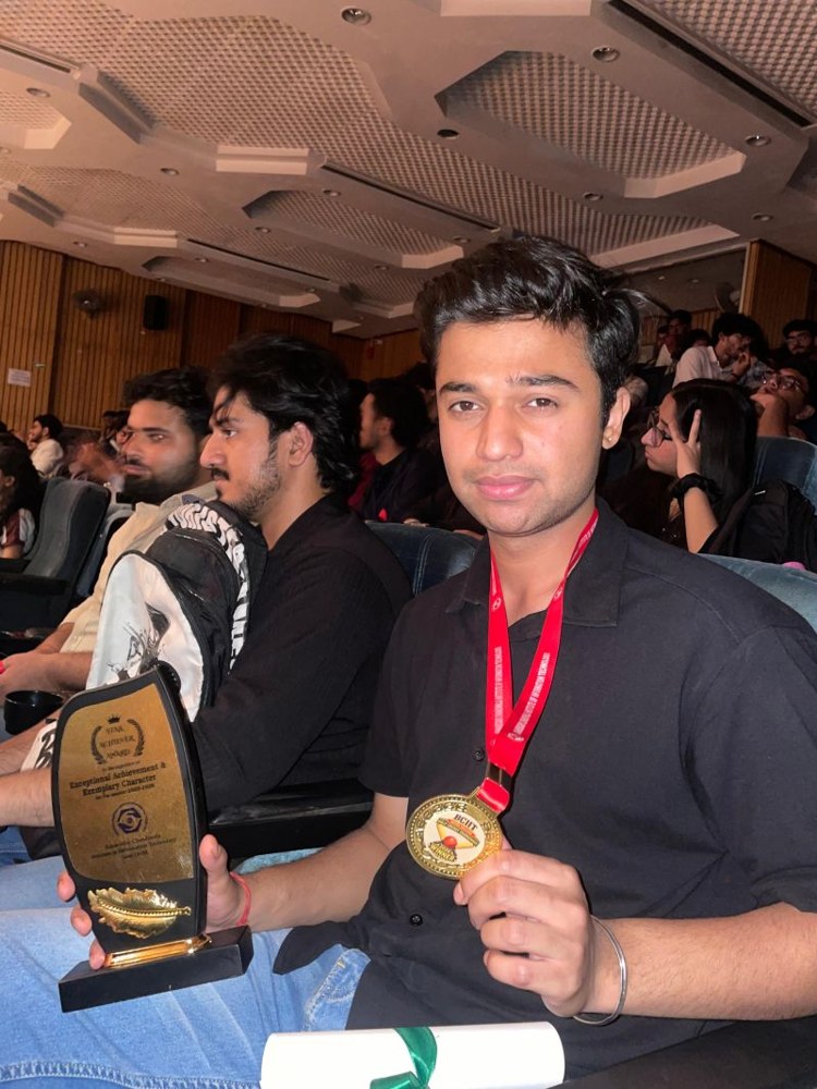 Aaditya holding his cricket gold medal and appreciation award